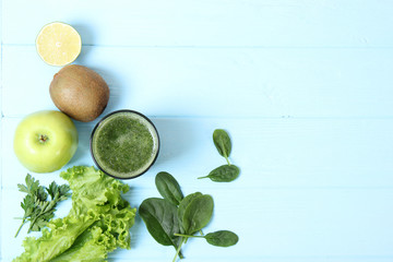 Green smoothie and fresh vegetables on the table for the detox organism top view.