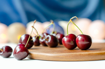 Ripe cherry close-up. Garlands are burning. Wood