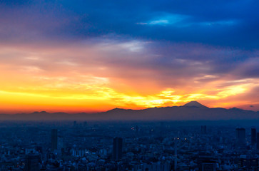 The sun sets over the cityscape of Tokyo, with Mount Fuji in the far distance view from Mori tower , roppongi hills , tokyo