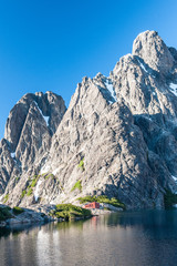 Stunning reflection of Andes mountains and Refugio Italia Manfredo Segre in Laguna Negra lake in Patagonia, Argentina. Winter backpacking. Pampa Linda trek. Hiking, camping and backpacking on iceberg 