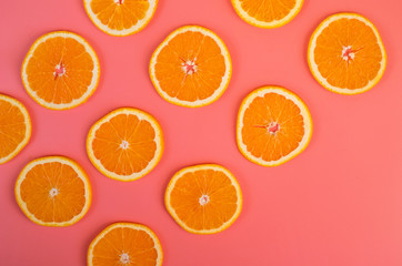 Background of ripe oranges cut on pink background