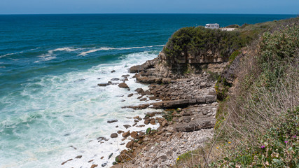 Camper van at the top of a cliff with the blue ocean & sky iin the background. taken in Sintra, Portugal