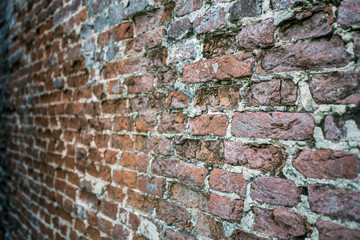 Weathered stained old brick wall background texture, selective focus