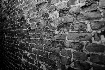 Weathered stained old brick wall background texture, selective focus black and white