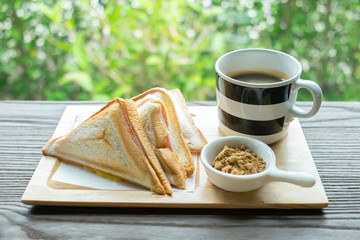 cup of coffee and red sugar with toasted ham and ham cheese sandwich, Morning light
