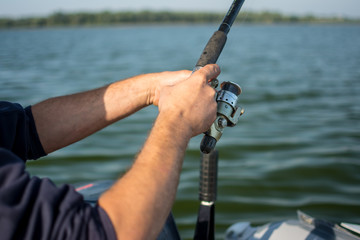 spinning reel in hands on a boat