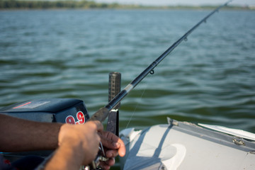 spinning reel in hands on a boat