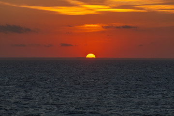Naklejka na ściany i meble Sunset behind the profile of the Adriatic coast that colors the sky with orange