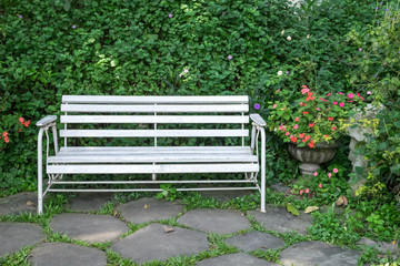 white benches in a green garden