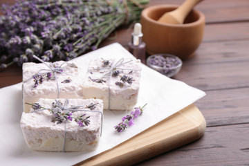 Obraz na płótnie Canvas Hand made soap bars with lavender flowers on wooden table