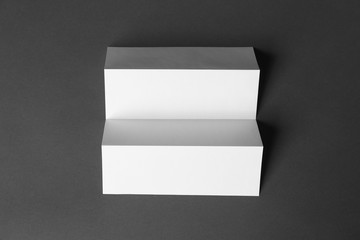 Blank brochure on dark grey background, top view. Mock up for design
