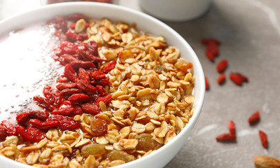 Smoothie bowl with goji berries on beige marble table, closeup
