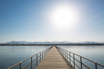 Obraz premium Wooden pier extending into the distance. Mountains on the horizon. Red Sea, Egypt