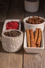 assortment of spices in pottery ordered on a rustic table