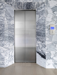Front view of a mable elevator with closed doors in building