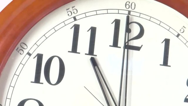 Close-up of a vintage clock face at 11 o'clock with a second hand moving