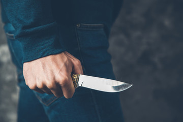 man hand holding knife on abstract background