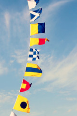 Marine signal flags against of a cloudy sky.