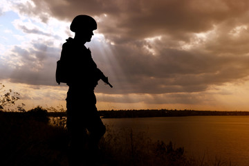 Soldier with machine gun patrolling outdoors. Military service