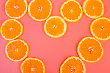 Background of ripe oranges cut on pink background