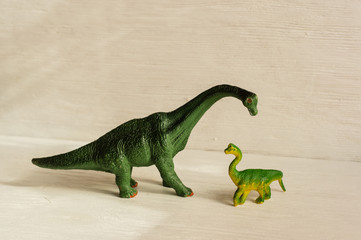 figurine of a bracheosaurus and its cub. offspring care concept. plastic dinosaur figures of extinct ancient creatures and  favorite toys of kids