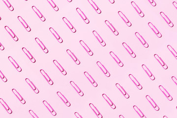 Pattern of pink paper clips on pastel background. Back to school. Office, business, paperwork, education concept. Banner