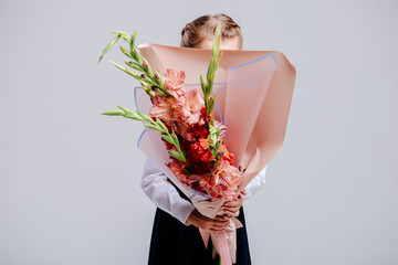 A bouquet of gladiolus in the hands of girl