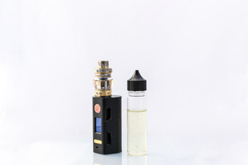 A electric cigarette vape deice with a bottle of liquid stood next to it. Shot against a clean white background