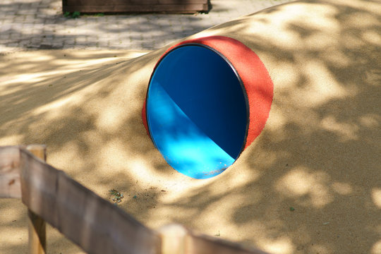 Ein gro&szlig;es Krabbelrohr unter einem Kieshaufen auf einem Spielplatz. ..