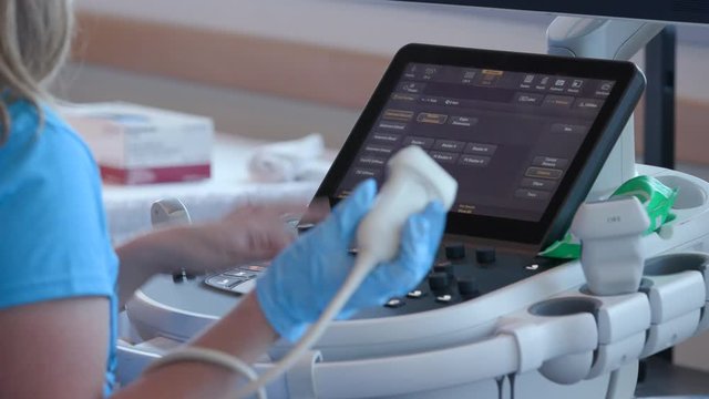 Sonographer adjusting dials