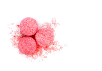 Pink bath bombs and bath salt on a white background, top view.