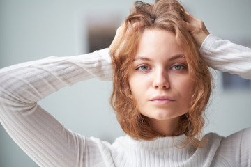 Fototapeta premium portrait of a beautiful curly girl. the mysterious face of a woman at the window.