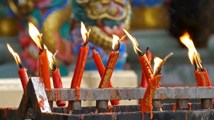 Video 4k of flame from burning red chinese candle in the temple
