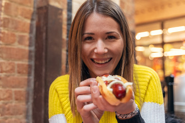 happy woman eating a hot dog