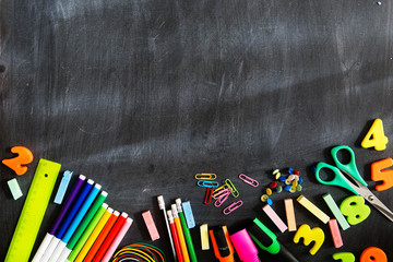 Back to school. School supplies on the background of the blackboard ready for your design. Copy space for text