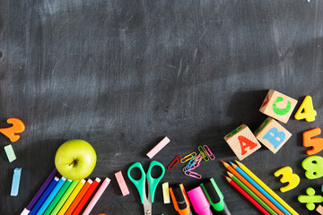 Back to school. School supplies on the background of the blackboard ready for your design. Copy space for text
