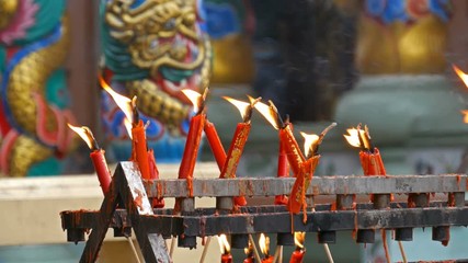Video 4k of flame from burning red chinese candle in the temple