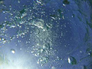 Fototapeta na wymiar Underwater bubbles with sunlight through water surface as seen in natural scene at Caribbean turquoise open ocean sea