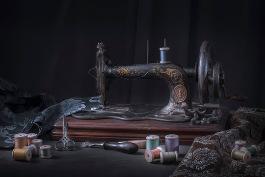 The sewing machine and accessories - threads, needle, scissors, measuring tape.