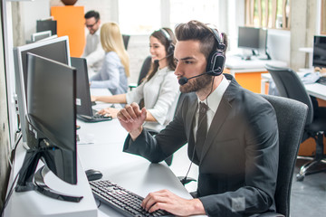 Group of telephone operators working in call center.