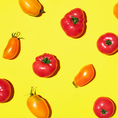 Yellow and red tomatoes pattern on yellow background. Flat lay, top view. Summer minimal concept. Vegan and vegetarian diet.