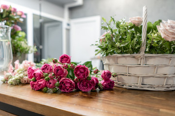 Woman florist create flower arrangement in a wicker basket. Beautiful bouquet of mixed flowers. Floral shop concept . Handsome fresh bouquet. Flowers delivery