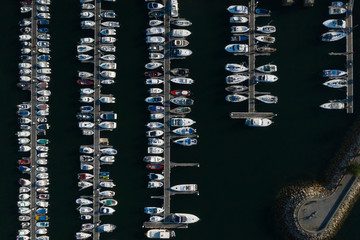 white yachts at the berths in the seaport, aerial view from drone