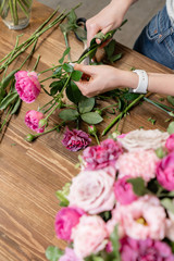 Woman florist create flower arrangement in a wicker basket. Beautiful bouquet of mixed flowers. Floral shop concept . Handsome fresh bouquet. Flowers delivery
