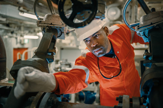 Uniformed employee with gloves handling machinery