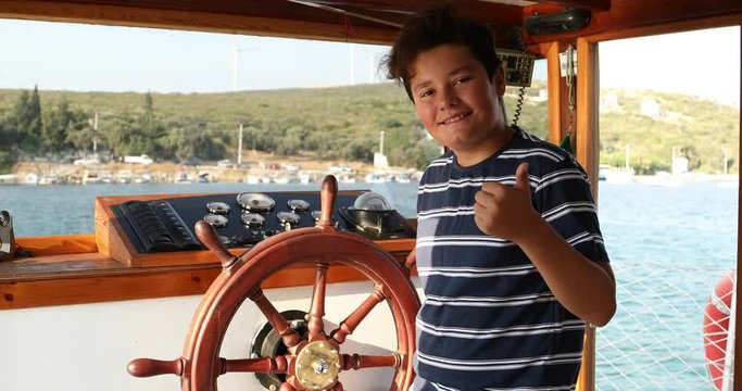 Young male skipper hands on a steering wheel of a boat motoring in mediterranean Sea