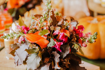 Flower center piece in autumn colours. Table decoration.