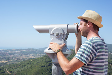 Obraz premium Male tourtist using a telescope. Summer holidays. 