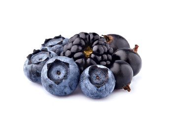 Fresh ripe black berries in closeup on white background. Blackberry with black currant berry and blueberries isolated.