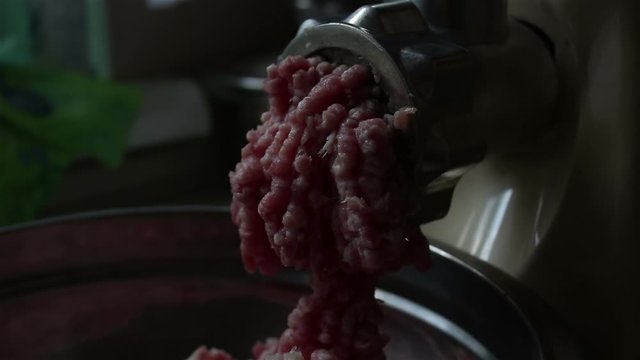 Close-up meat grinder grinds fresh meat into minced meat.Chef cooks fresh minced meat in an electric mincing machine.